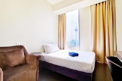 a room with a bed and a couch and a window at Tropicana The Residences KLCC By Luxury Suites in Kuala Lumpur