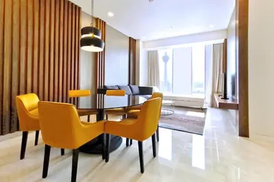a dining room with a table and yellow chairs at Tropicana The Residences KLCC By Luxury Suites in Kuala Lumpur
