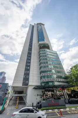 a tall building with cars parked in front of it at Lila Suites One Bukit Ceylon in Kuala Lumpur