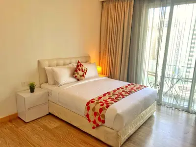 a bedroom with a bed and a large window at Lila Suites One Bukit Ceylon in Kuala Lumpur
