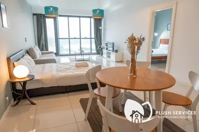 a living room with a bed and a table at Mcity at Jalan Ampang in Kuala Lumpur