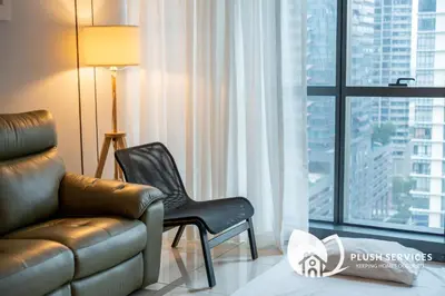a living room with a couch and a chair in front of a window at Mcity at Jalan Ampang in Kuala Lumpur