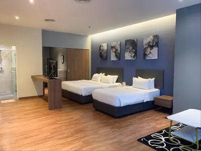 a hotel room with two beds and a television at The Infinite - Bangsar Trade Centre in Kuala Lumpur