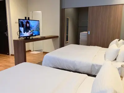 a hotel room with two beds and a flat screen tv at The Infinite - Bangsar Trade Centre in Kuala Lumpur