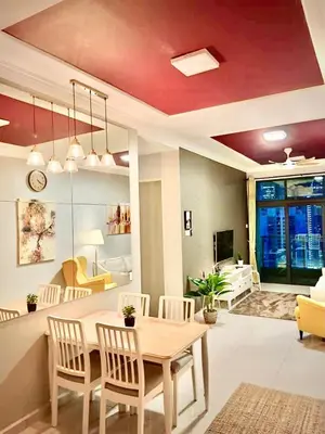 a dining room and living room with a table and chairs at 3 Bedrooms Short Stays Condo at KLCC in Kuala Lumpur