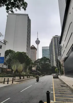 a motorcycle driving down a city street with buildings at City Home Suites Kuala Lumpur City Centre in Kuala Lumpur
