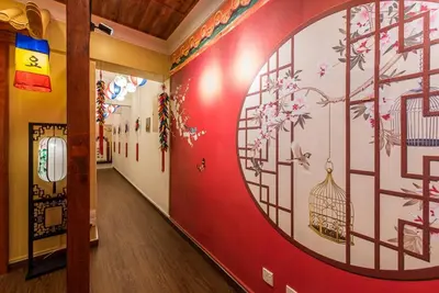 a hallway with a red wall with a bird cage painted on it at Fahrenheit88-Korea Theme Bukit Bintang Kuala Lumpur 2R2B 6Pax in Kuala Lumpur