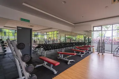 a gym with rows of exercise equipment in a room at Peaceful 3-bedroom with Pool 5 pax - Wangsa Maju in Kuala Lumpur