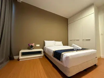a bedroom with a large bed and a table at Platinum KLCC By Rainbow Suites in Kuala Lumpur