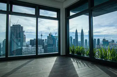 a room with large windows with a view of the city at Eaton Residences KLCC by Plush in Kuala Lumpur