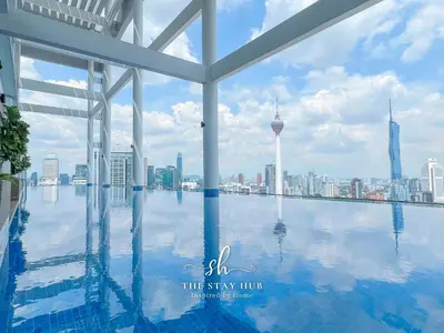 a view of the city from a swimming pool at the stay true hotel at The Luxe & Colony KLCC Skyline Infinity Pool - 5min to Petronas Tower & KL City Center by The Stay Hub in Kuala Lumpur