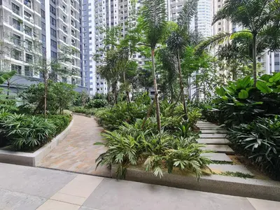 a walkway in a city with palm trees and buildings at Bangsar South Apartment by Sarah's Lodge @ SouthLink Lifestyle Apartment in Kuala Lumpur