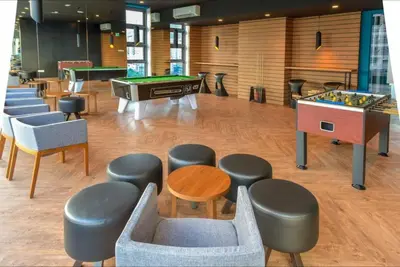 a room with a ping pong table and some chairs at Robertson Suites Bukit Bintang with Netflix in Kuala Lumpur