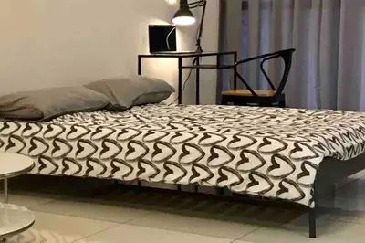 a bed with a black and white comforter in a bedroom at Flexi check in 10min to KLCC next to Hospital Gleneagle in Kuala Lumpur