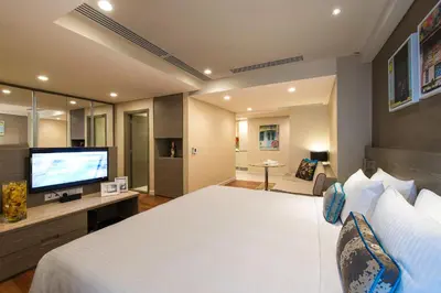 a bedroom with a large white bed and a flat screen tv at Ascott Sentral Kuala Lumpur in Kuala Lumpur