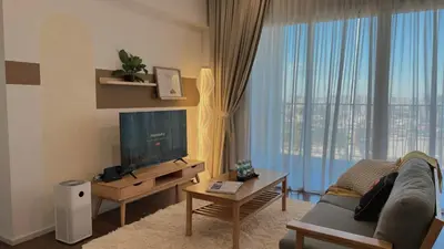 a living room with a couch and a large window at UNA Serviced Apartment by manatidur in Kuala Lumpur