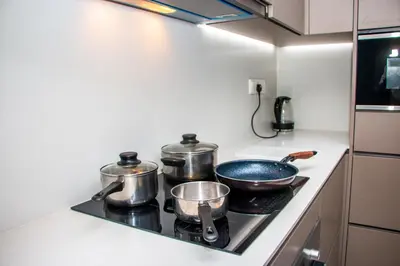 a kitchen with two pots and pans on a stove at Eaton Residence KLCC by Yemala in Kuala Lumpur