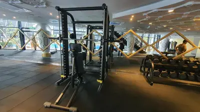 a gym with a bunch of weights in a room at Arte Mont Kiara Studio by BeeStay in Kuala Lumpur
