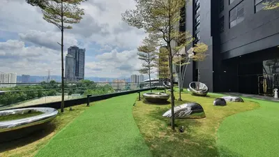 a garden with rocks and trees on the side of a building at Arte Mont Kiara Studio by BeeStay in Kuala Lumpur