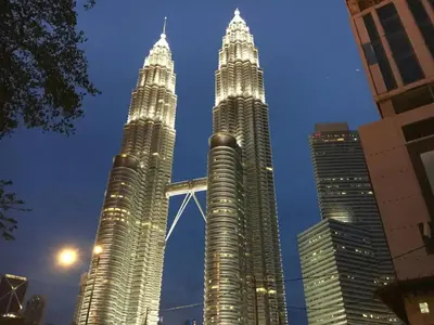 two tall skyscrapers in a city at night at Maxhome Plus at Dorsett Bukit Bintang in Kuala Lumpur