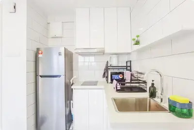 a white kitchen with a refrigerator and a sink at Arte Mont Kiara Kuala Lumpur in Kuala Lumpur