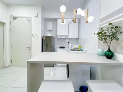 a white kitchen with a large white counter top at Arte Mont Kiara Kuala Lumpur in Kuala Lumpur