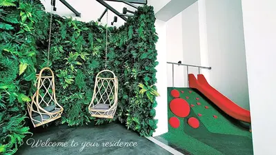 a play room with a green wall and a red slide at Awesome Designer Suite 3-Beds Near TRX KLCC, Next to IKEA in Kuala Lumpur