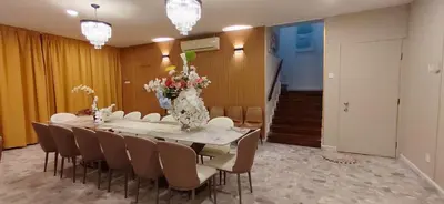 a dining room with a table with chairs and a vase of flowers at Bukit Tunku KLCC Grande Villa 11 by Vale Pine in Kuala Lumpur