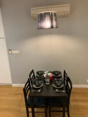 a dining room table with a black table and chairs at Platinum Suites by Homie SkyBay in Kuala Lumpur