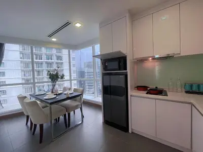 a kitchen with a table with chairs and a counter top at LUX SUITES KL City Pavilion Bukit Bintang with INFINITY POOL in Kuala Lumpur