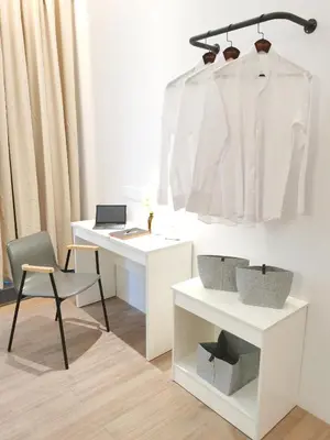 a white desk with a chair and a white shirt on a rack at The President - Bangsar South Mid Valley in Kuala Lumpur