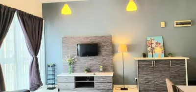 a living room with a tv on a brick wall at Regalia Suites KLCC View Rooftop Infinity Pool by SHI in Kuala Lumpur