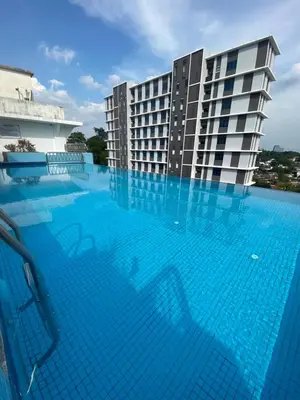a large swimming pool in front of a building at Peninsula Residences All Suite Hotel in Kuala Lumpur