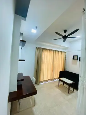 a living room with a couch and a ceiling fan at Peninsula Residences All Suite Hotel in Kuala Lumpur