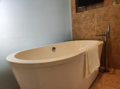 a white bath tub in a bathroom with a television at Dorsett Residence KL Private Studio apartment in Kuala Lumpur