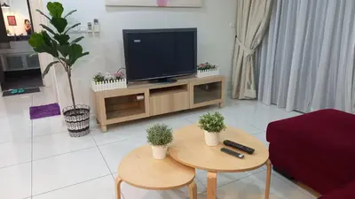 a living room with two tables and a television at ESTELAR Apartments at Mercu Summer KLCC in Kuala Lumpur