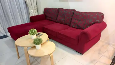 a living room with a red couch and two tables at ESTELAR Apartments at Mercu Summer KLCC in Kuala Lumpur