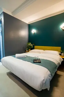 a large bed in a room with a blue wall at Hotel 28 Chow Kit Kuala Lumpur in Kuala Lumpur