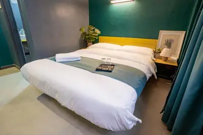 a large bed in a room with a green wall at Hotel 28 Chow Kit Kuala Lumpur in Kuala Lumpur
