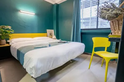 a bedroom with a large bed and a yellow chair at Hotel 28 Chow Kit Kuala Lumpur in Kuala Lumpur