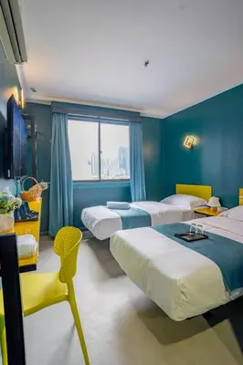 a hotel room with four beds and a window at Hotel 28 Chow Kit Kuala Lumpur in Kuala Lumpur