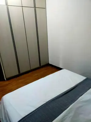a bedroom with a bed with white sheets and white cabinets at Omar's place 4 - Best view of KLCC Twin Towers. in Kuala Lumpur