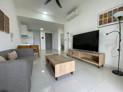 a living room with a couch and a large flat screen tv at Infini Suites@ Continew Residence KL in Kuala Lumpur