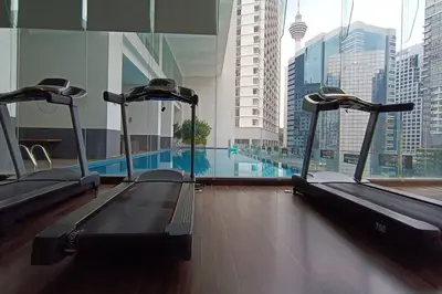 a gym with a swimming pool in a building at A05 Bukit Ceylon KL Tower View Balcony Apartment in Kuala Lumpur