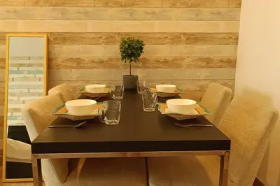a dining room table with chairs and a table with a plant on it at A05 Bukit Ceylon KL Tower View Balcony Apartment in Kuala Lumpur