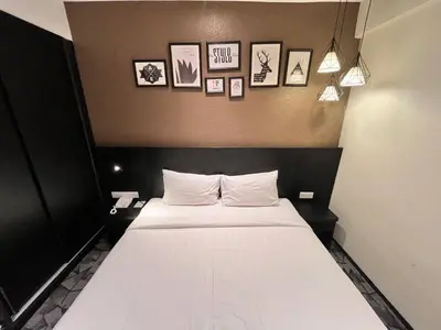 a bed in a room with pictures on the wall at Hotel Damai Kuala Lumpur in Kuala Lumpur