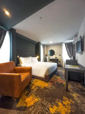 a hotel room with a bed and a couch at Trigo Hotel Kuala Lumpur in Kuala Lumpur