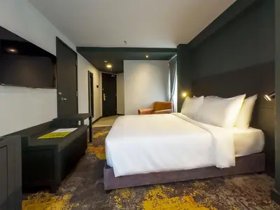 a bedroom with a large white bed and a desk at Trigo Hotel Kuala Lumpur in Kuala Lumpur