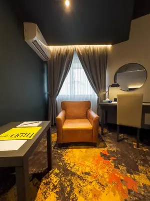a living room with a chair and a table at Trigo Hotel Kuala Lumpur in Kuala Lumpur