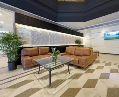 a lobby with two couches and a glass table at Trigo Hotel Kuala Lumpur in Kuala Lumpur